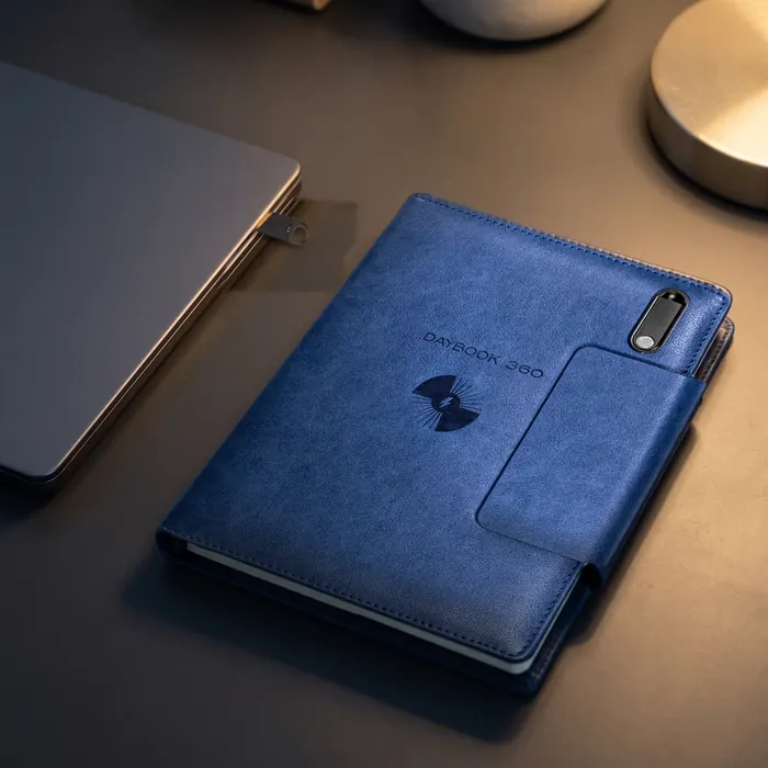 Illustration: the 64 GB USB drive from the navy DAYBOOK 360 plugged into a laptop’s USB-A port, the closed planner beside it with its empty drive slot